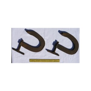 May include: Two rusty metal C-clamps with a wooden handle. The clamps are on a white surface with a wooden ruler.