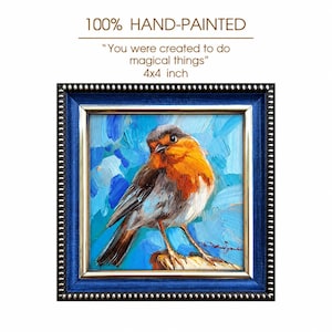 May include: A 4x4 inch hand-painted oil painting of a robin with an orange breast and grey wings, set against a textured blue background. The artwork is enclosed in a dark blue frame with gold trim and features the text 100% HAND-PAINTED and You were created to do magical things.