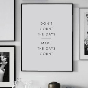 May include: Black and white motivational quote print in a black frame. The quote reads "Don't count the days, make the days count."