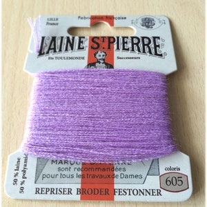 May include: A spool of purple embroidery floss labeled "Laine St. Pierre" with the text "50% laine 50% polyamid" and "coloris 605".
