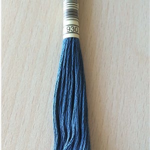 Peut inclure: Une pelote de fil à broder bleu foncé avec une étiquette indiquant "930".