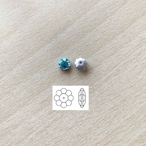 May include: Two turquoise flower-shaped rhinestones with silver settings. The rhinestones are shown next to a line drawing of the rhinestone.
