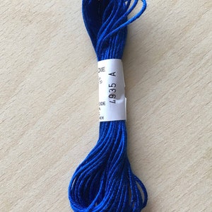 Könnte beinhalten: Ein Knäuel blauer Stickgarn mit einem weißen Etikett, auf dem "4935 A" steht.