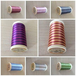 May include: A collection of ten spools of thread in various colors and patterns. The spools are all the same size and shape, and they are made of a white plastic material. The thread is wound around the spools, and the ends of the thread are visible. The spools are arranged in a grid pattern, with three rows and four columns.