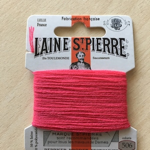 May include: A spool of bright pink Laine S. Pierre thread, color 506, with a white and orange label. The label includes text in French, indicating it's made in Lille, France. The thread is 50% wool and 50% polyamide.