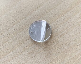 May include: A clear round mirror with two small holes on the edge.