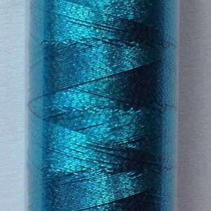 May include: A spool of teal metallic thread with the brand name "Mettler" and the text "No. 40 100m" printed on the label.