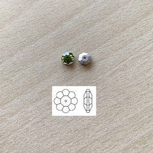 May include: Two green flower-shaped rhinestones with a silver backing. The rhinestones are shown next to a line drawing of the rhinestone.
