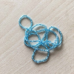 Peut inclure: Un brin de perles de verre bleu clair, parfait pour la fabrication de bijoux ou l'artisanat.