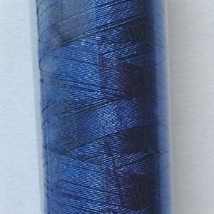 Può includere: Un'bobina di filo blu con un'etichetta bianca che recita "Art. 7633" e "No. 40 100".