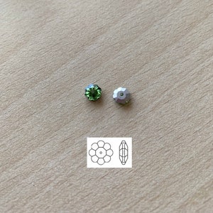 May include: Two green glass beads with a silver metal bead. The beads are round and have a flat back. The beads are shown next to a diagram of the beads.