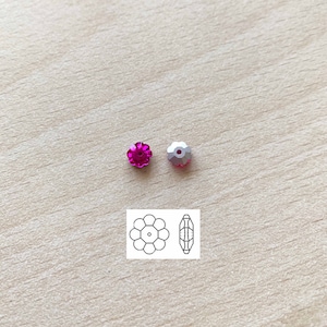 May include: Two flower-shaped crystal beads, one in pink and one in silver. The beads are shown next to a line drawing of the bead.