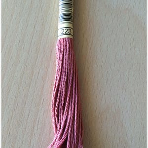 May include: A spool of pink embroidery floss with a label that reads "223".