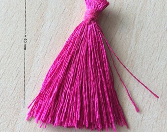 May include: A bright pink tassel approximately 40 mm long. The tassel is made of soft, thin fibers and has a rounded shape.