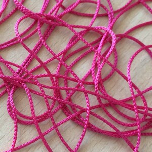 Peut inclure: Gros plan d'un tas de cordon rose vif emmêlé.