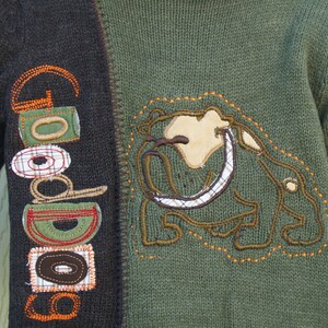 May include: A green and brown sweater with a brown and white embroidered bulldog on the front. The sweater has the word "Good" embroidered on the left sleeve.