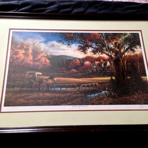 May include: A framed print of a painting depicting a horse-drawn wagon traveling through a rural landscape with a farmhouse in the background. The painting is titled "Nostalgia's Mirror".