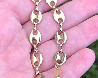 May include: A gold-toned bracelet with a mariner link chain style. The bracelet has a lobster clasp closure.