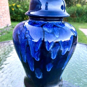May include: A blue and black ceramic jar with a lid. The jar has a unique glaze that creates a marbled effect.