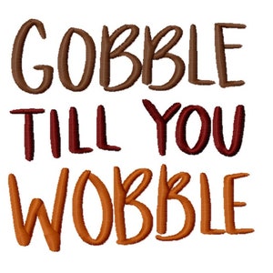 May include: Embroidered text on a white background reads "GOBBLE TILL YOU WOBBLE" in shades of brown, red, and orange. The text is in a playful, handwritten style, perfect for Thanksgiving or autumn-themed crafts and decor.