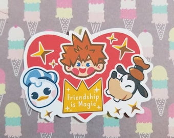 以下が含まれることがあります： 漫画のキャラクター、ソラ、ドナルドダック、グーフィーが描かれたステッカー。キャラクターは、黄色の王冠に「Friendship is Magic」という文字が入った赤いハートの周りに配置されています。背景はアイスクリームコーンのパターンです。