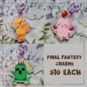 May include: Three Final Fantasy character charms with heart-shaped clasps. The charms feature a yellow bird, a pink cat with wings, and a green cactus. The text "FINAL FANTASY CHARMS" is also visible.
