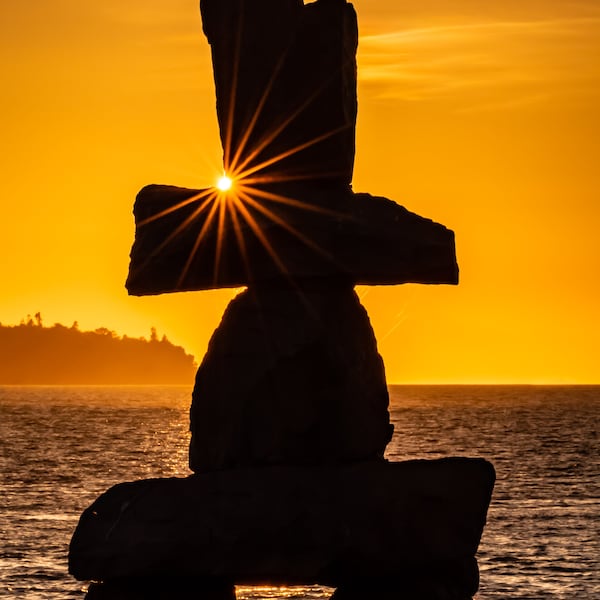 Vancouver, Canada, Inukshuk sculpture overlooking English Bay at Sunset