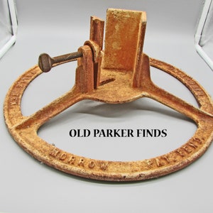 May include: Rusty metal Christmas tree stand with a circular base and a screw to adjust the height. The base is inscribed with "Morrow Patent" and "The Morrow Tree Stand".