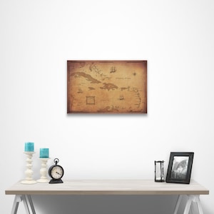 May include: A vintage-style map of the Caribbean islands with the text "Atlantic Ocean" printed on the map. The map is printed on a brown background with a distressed look. The map is framed and hanging on a white wall.