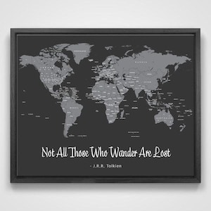 May include: A black framed world map with a grey background and a quote from J.R.R. Tolkien: "Not All Those Who Wander Are Lost".