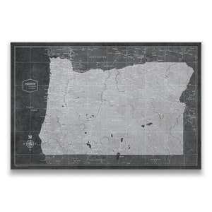 May include: A vintage-style map of Oregon with a black background and white lines showing roads and cities. The map is surrounded by a black border and includes the names of surrounding states.