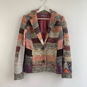 May include: A multi-colored striped knitted blazer with a patchwork design. The blazer has a single button closure and a burgundy lining. The label on the blazer reads "LOLO P."