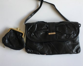 Könnte beinhalten: Schwarze Leder-Umhängetasche mit goldfarbenem Verschluss und goldenem Logo mit der Aufschrift "STEFANOR". Die Tasche hat ein gestepptes Design und wird mit einer passenden schwarzen Leder-Münzbörse geliefert.