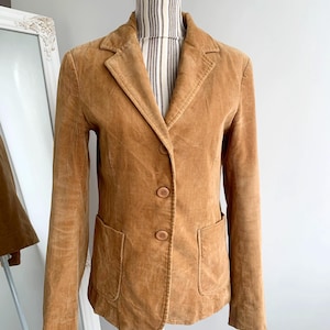 May include: A brown corduroy blazer with a single-breasted closure and two front pockets.