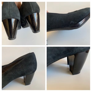 May include: Black suede heeled pumps with a black patent leather heel. The shoes have a pointed toe and a closed back.