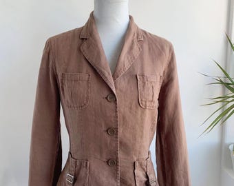May include: A brown blazer with a classic design, featuring a notched collar, three-button closure, and four front pockets. The blazer is displayed on a mannequin, showcasing its tailored fit and details like the pocket flaps and buckle accents.