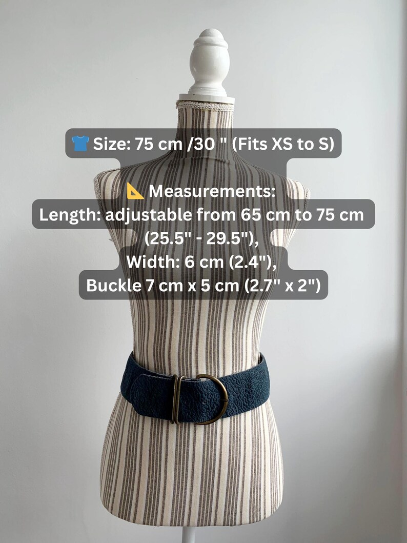 May include: A navy blue belt with a textured surface and a gold-coloured buckle. The belt is displayed on a mannequin. The belt is adjustable from 65 cm to 75 cm and is 6 cm wide. The buckle is 7 cm x 5 cm.