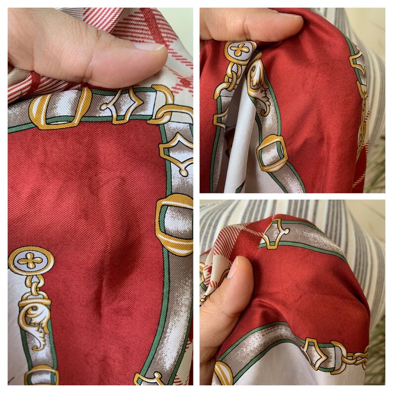 May include: Red silk scarf with a white and green pattern of chains and buckles. The scarf has a subtle plaid pattern in the background.