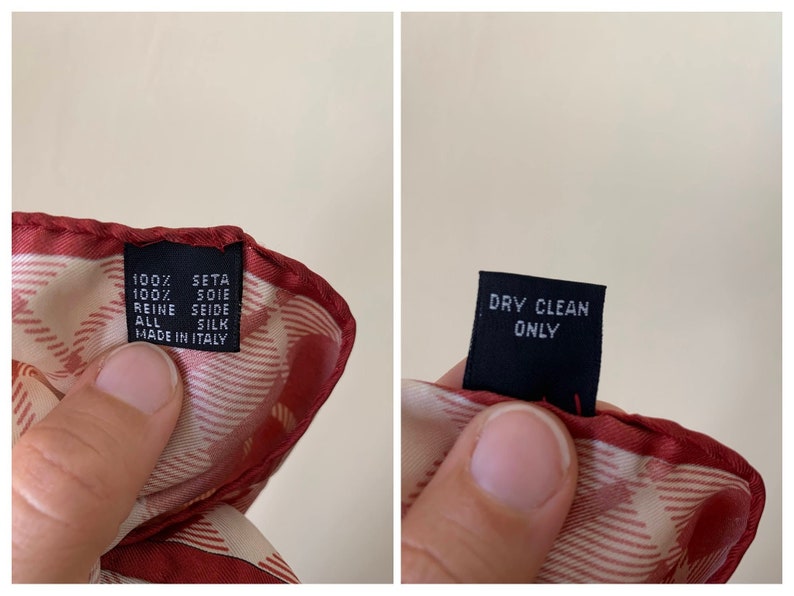 May include: A red and white silk scarf with a label that reads "100% seta 100% soie reine seide all silk made in Italy" and a separate label that reads "dry clean only".