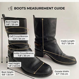 May include: A pair of black leather boots with a low heel and a strap detail. The image includes a measurement guide with text: SIZE: EUR 39 (Marked) Fit approx.: UK 6, US 8. Boot Height: 9.8 inches, Calf Circumference: 13.4 inches, Ankle Circumference: 11.8 inches.