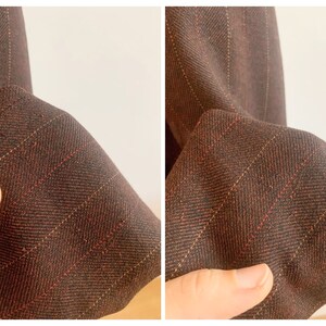 May include: Close-up of a brown and red striped fabric with a subtle herringbone pattern. The fabric is soft and has a smooth texture.