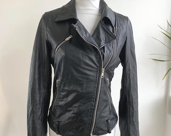 May include: A black leather jacket with a classic asymmetrical zipper closure. The jacket features multiple zippered pockets and a notched collar. The garment is displayed on a white mannequin against a neutral background.
