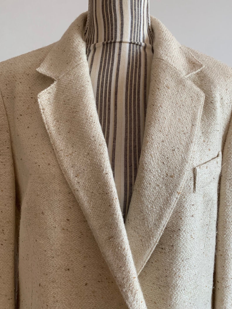 Peut inclure: Un blazer cr&egrave;me avec une texture tiss&eacute;e. Le blazer a un revers crant&eacute; classique et une fermeture &agrave; un bouton.
