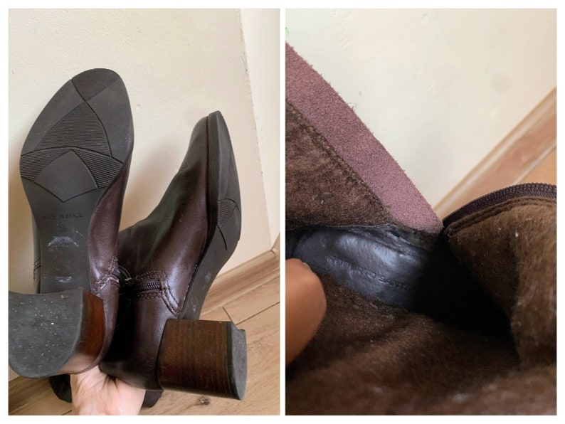 May include: A pair of brown leather ankle boots with a block heel. The boots have a zipper on the inside of the ankle and a brown suede lining.