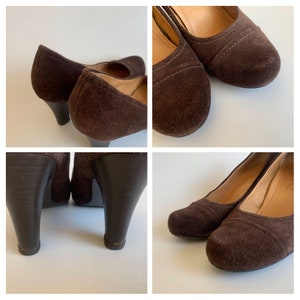 May include: A pair of brown suede heeled pumps with a rounded toe. The heels are about 3 inches tall and the shoes have a subtle stitching detail around the toe.