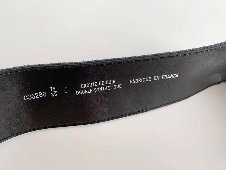 May include: Black leather belt with embossed text including "CROUTE DE CUIR DOUBLE SYNTHETIQUE" and "FABRIQUE EN FRANCE". The belt is 75 cm wide and 30 inches long. The belt has the number "035280" printed on it.