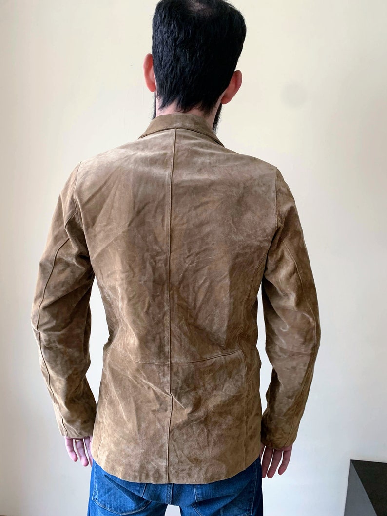 May include: A brown suede jacket with a button-up front and long sleeves.