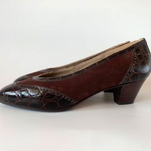 May include: Brown suede and crocodile-embossed leather heeled pumps with a pointed toe.