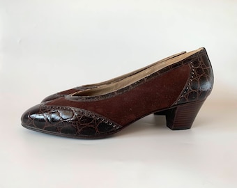 Puede incluir: Zapatos de tacón de charol marrón y piel con estampado de cocodrilo de punta.