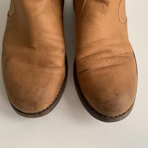 May include: A pair of brown leather ankle boots with a pointed toe and a low heel.